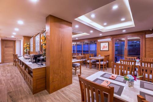 a restaurant with tables and chairs and a counter at Jomkitti Boutique Hotel in Chiang Mai