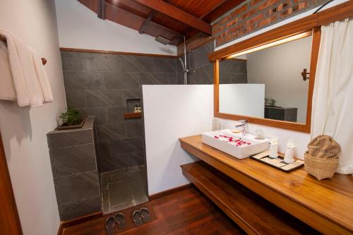 a bathroom with a sink and a mirror at Popa Garden Resort in Popaywa