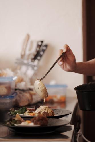a person eating food with a spoon on a plate at YUKARA LEAF LODGE in Nanae