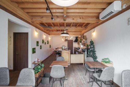 uma sala de jantar com mesas e cadeiras e uma cozinha em YUKARA LEAF LODGE em Nanae