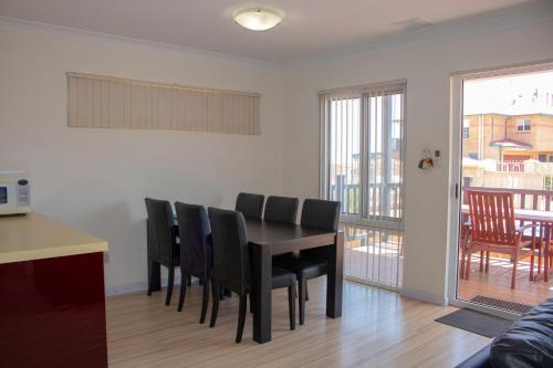 a dining room with a table and black chairs at Seaspray Beach Holiday Park in Dongara