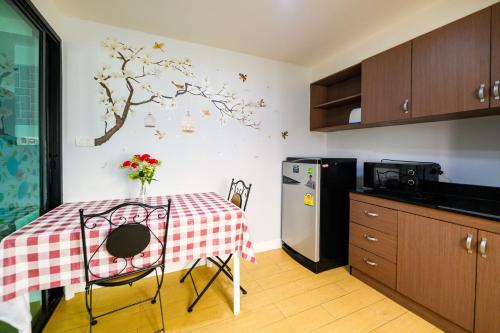 a kitchen with a table and a refrigerator at Scandia Beach Hotel - Soi 7 Best Location - 200m to Beach next to Food Market in Jomtien Beach