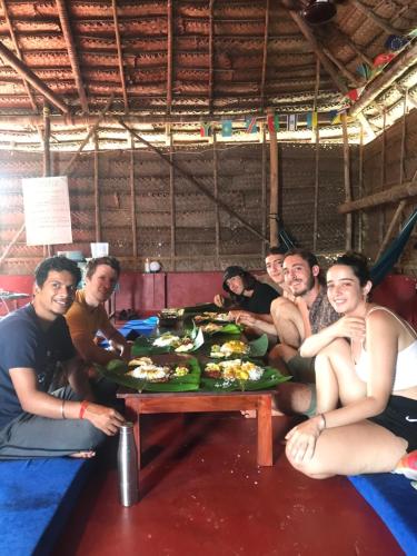 a group of people sitting around a table with food at HostelExp, Varkala - A Beach Town Hostel in Varkala