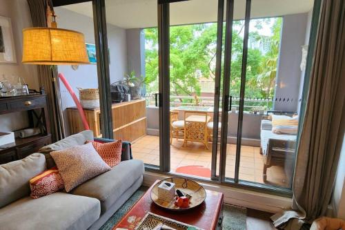 a living room with a couch and a large sliding glass door at Homely Apartment In Sought After Building in Sydney