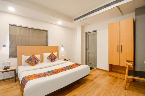 a bedroom with a large bed and a desk at FabHotel Airport Green Arcade in Kolkata