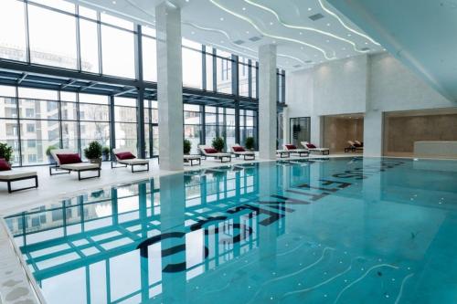 a large swimming pool in a building with windows at Sabah Residance in Baku