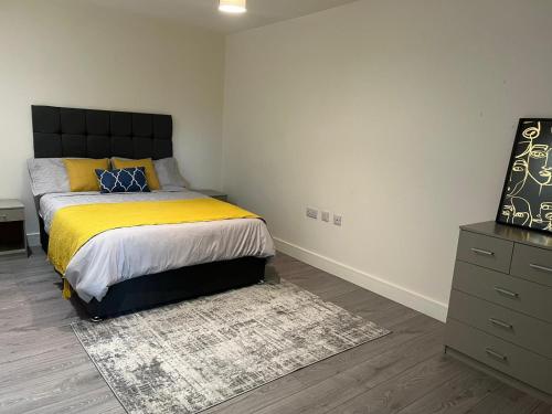 a bedroom with a king sized bed and a dresser at Modern 1 bedroom flat high street, great location in Hemel Hempstead