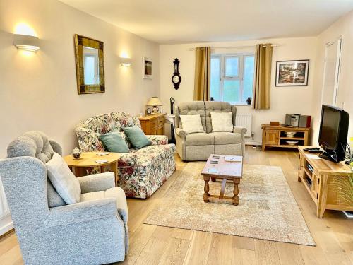 a living room with two couches and a tv at Clematis House in Dorchester