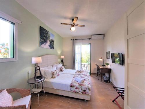 - une chambre avec un lit et un ventilateur de plafond dans l'établissement BELLA CISTERNA, à Kambos