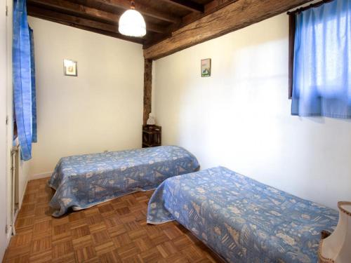 Gîte Saint-Médard-en-Forez, 3 pièces, 4 personnes - FR-1-496-283 في Saint-Médard-en-Forez: سريرين في غرفة ذات أغطية زرقاء