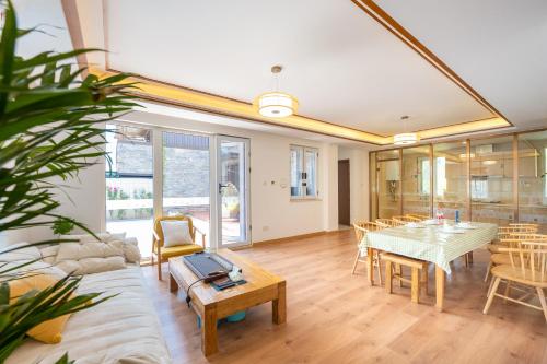 a large living room with a table and chairs at Gubei Water Town Landscape Villa in Miyun