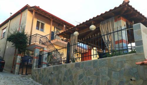 a house with balconies and a stone wall at BAKIRAS HOUSE in Sikia