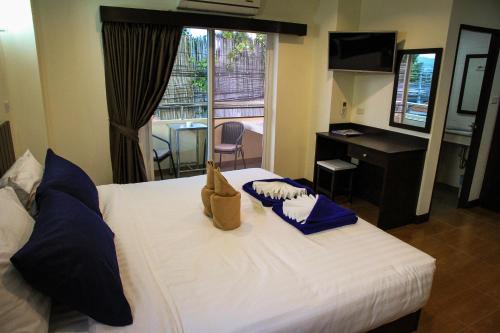 a bedroom with a white bed with blue pillows and a desk at Sky Villa Hua Hin Guesthouse - Adults-Only in Hua Hin