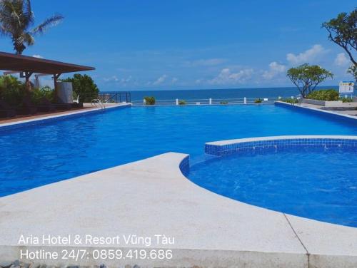 a large swimming pool with the ocean in the background at Căn hộ biển Aria Vũng Tàu in Xa Thang Nhut