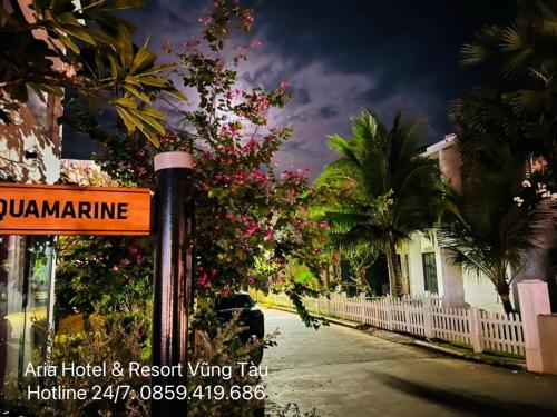 a street sign in front of a house with flowers at Căn hộ biển Aria Vũng Tàu in Xa Thang Nhut