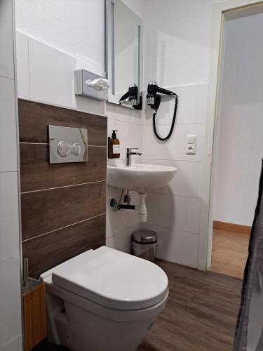 a bathroom with a toilet and a sink at Komfort Hotel Wiesbaden in Wiesbaden