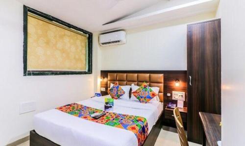 a bedroom with a bed and a table in it at FabHotel Galaxy Suite in Mumbai