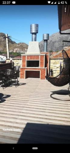 a large deck with chairs and a fireplace at Come & Rest in Stepantsminda