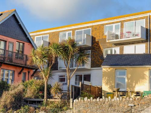a house with palm trees in front of a fence at 1 Bay View Court in Lyme Regis