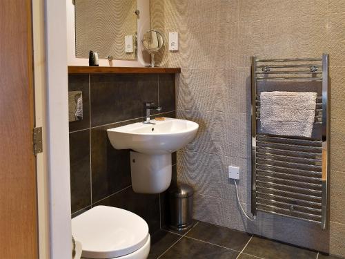 a bathroom with a sink and a toilet and a mirror at Strathspey in Grange