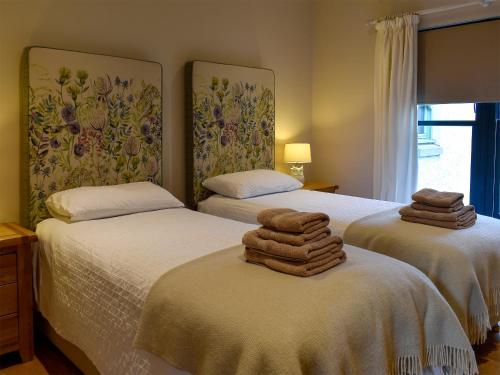 two beds with towels on them in a bedroom at Strathspey in Grange