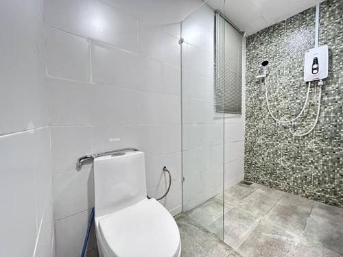 La salle de bains est pourvue de toilettes et d'une douche en verre. dans l'établissement Jeff and Ricky Homestay 73@Vivacity Megamall, à Kampong Tabuan
