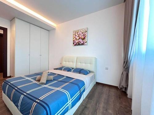 - une chambre dotée d'un grand lit avec des draps bleus et blancs dans l'établissement Jeff and Ricky Homestay 73@Vivacity Megamall, à Kampong Tabuan