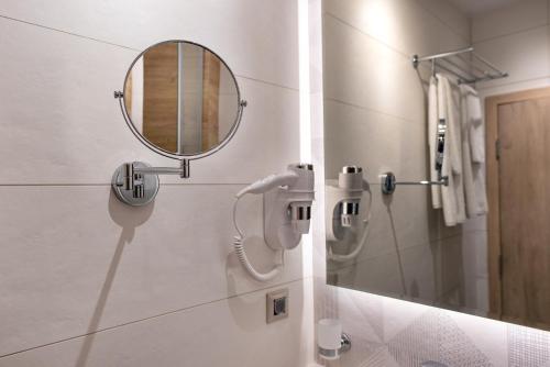 baño con espejo y lavabo en City Park Inn - Art Gallery en Plovdiv