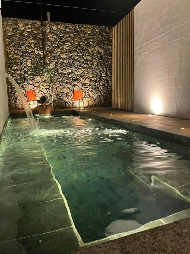 a swimming pool with a person in the water at Clos de la Rivière in Saint-Denis