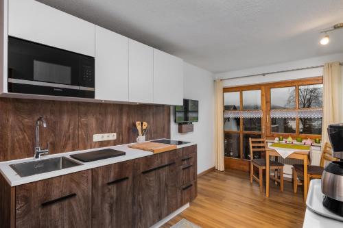 a kitchen with wooden cabinets and a dining room at Haus Seidl in Bodenmais