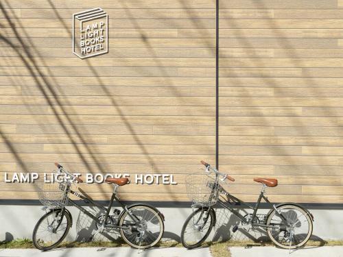 two bikes are parked next to a building at LAMP LIGHT BOOKS HOTEL fukuoka in Fukuoka