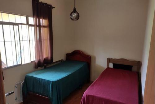 a bedroom with two beds and a window at Casa temporada com piscina in Lagoa dos Ingleses