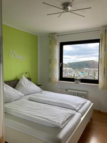 a bedroom with a large bed with a window at Ferienwohnung Heidi Winterberg in Winterberg