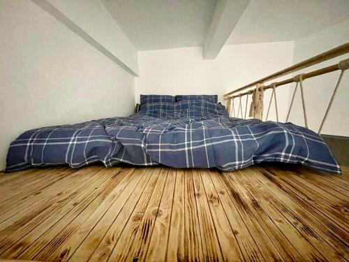 a bed in a room with a wooden floor at Vis-a-Vis Studio - Gara de Nord in Bucharest