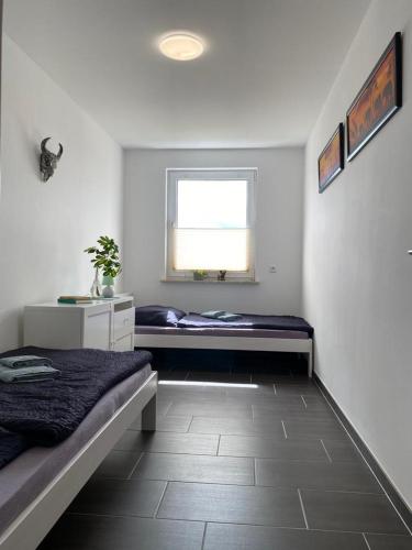 a bedroom with two beds and a window at Gästewohnung KL. WZL 29_7 in Klein Wanzleben