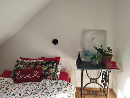 1 dormitorio con cama y mesa con almohada de amor en Terra Natangia, en Górowo Iławeckie