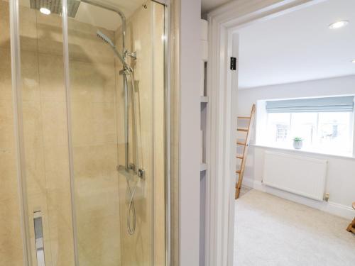 a glass shower in a bathroom with a window at Ashton House in Moreton in Marsh
