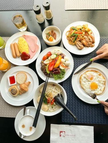 a table with plates of food on it at Hotel Clover Asoke - SHA Extra Plus in Bangkok