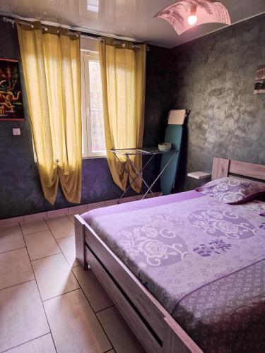 sypialnia z łóżkiem i żółtymi zasłonami w obiekcie Maison de 2 chambres avec wifi a Berlaimont w mieście Berlaimont