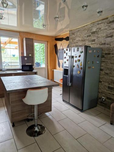 Il comprend une cuisine équipée d'un grand réfrigérateur en acier inoxydable. dans l'établissement Maison charmante à Berlaimont avec jardin et parking inclus, à Berlaimont