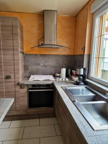 a kitchen with a sink and a stove at Maison charmante à Berlaimont avec jardin et parking inclus in Berlaimont