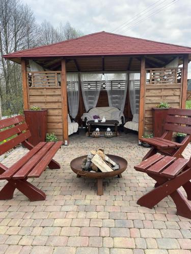 a gazebo with two benches and a fire pit at Agro na Wapniarni in Białla