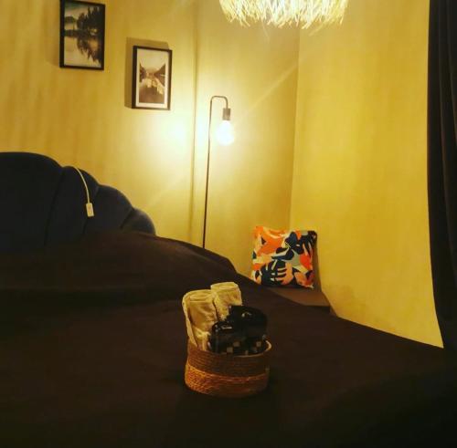 Cette chambre comprend un lit avec un panier et une lampe. dans l'établissement Chambres d'hôtes Chez Valérie, à Arette