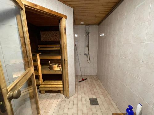 baño con ducha con puerta abierta en Miekkala Lomatalo en Ilottula