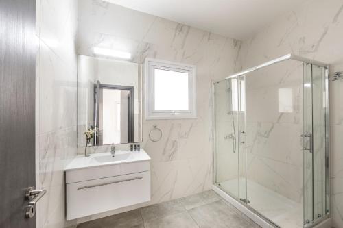 a white bathroom with a sink and a shower at Napa Bay View Villa 3 in Ayia Napa