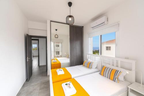 a room with two white beds and a large window at Napa Bay View Villa 3 in Ayia Napa