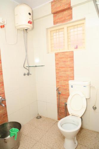 a bathroom with a toilet in a room at Sai Home Stay in Madikeri