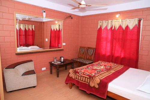 a bedroom with a bed with red walls and a mirror at Sai Home Stay in Madikeri