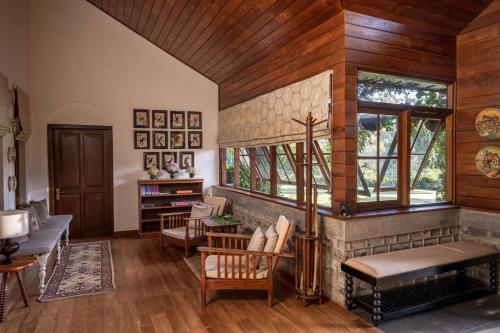 a living room with a fireplace and wooden walls at Stafford Bungalow in Nuwara Eliya