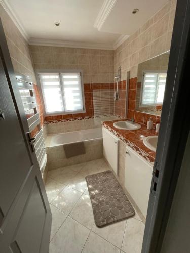 une salle de bain avec une baignoire et un lavabo et une baignoire dans l'établissement Villa Saveur Nature, à Cagnes-sur-Mer